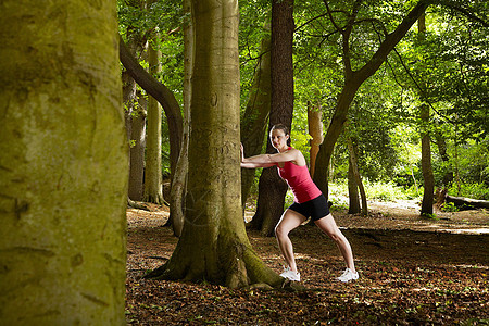 在森林中伸展的慢跑者图片