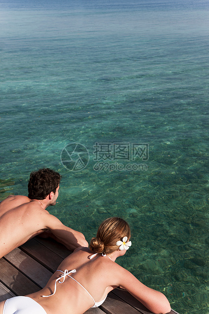夫妇躺在甲板上俯瞰大海图片