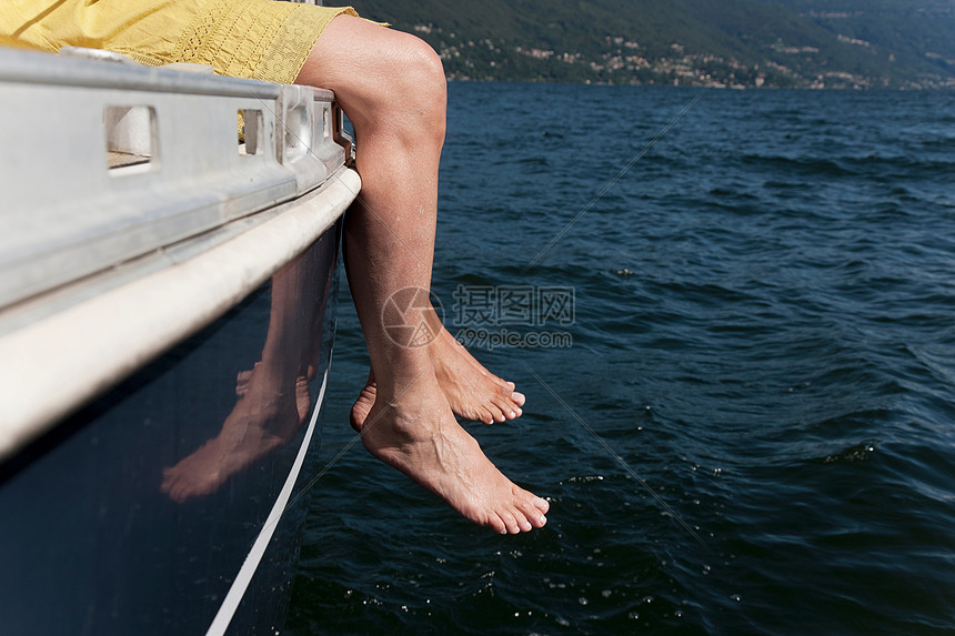 从帆船上垂下脚的女人图片