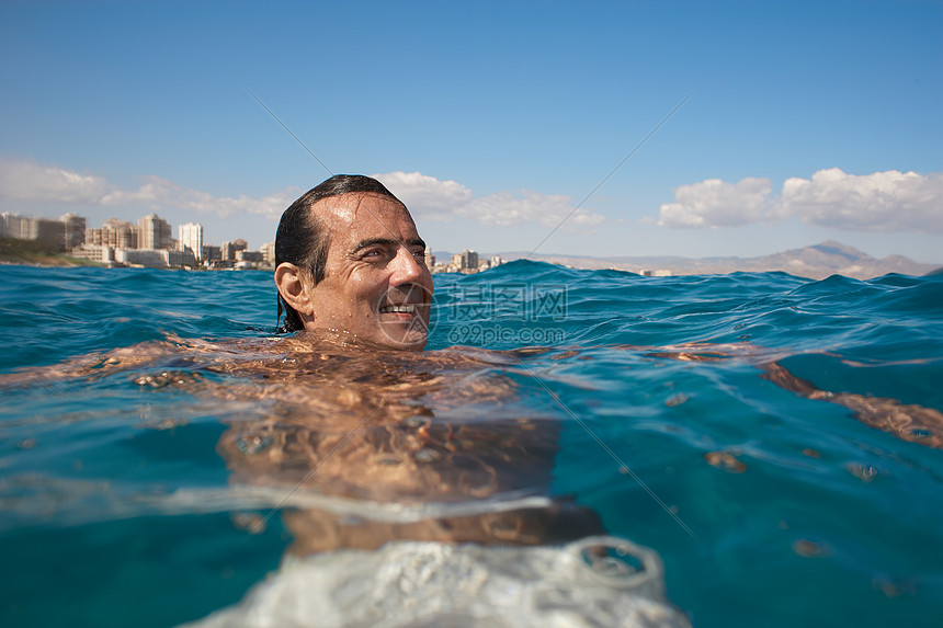成熟的男人在海里游泳微笑