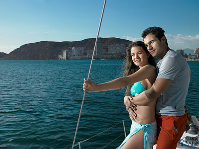 年轻夫妇站在游艇上微笑图片