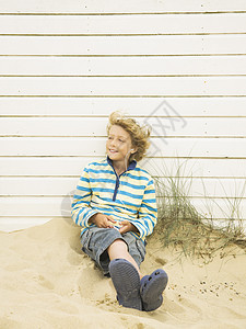 在海滩小屋边听音乐的男孩图片