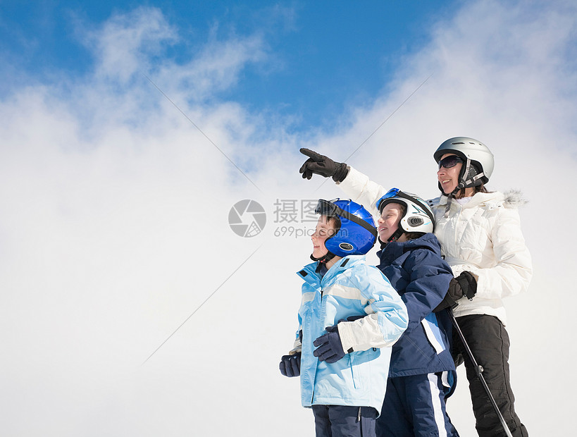 女人带着两个男孩指向天空图片