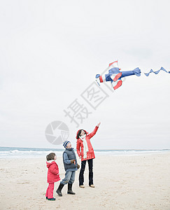 海滩上拿着风筝的人们图片