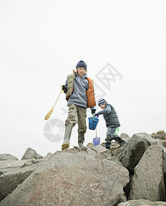 海滩岩石上的男孩图片