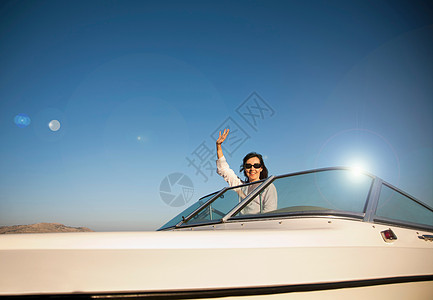 在快艇上挥手的女人图片