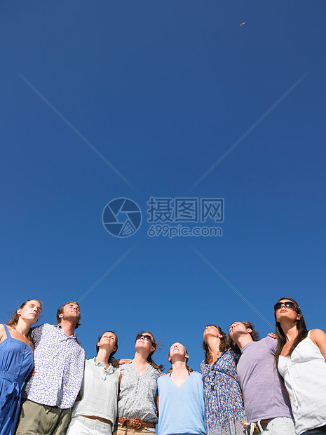 一群年轻人抬头看着太阳图片