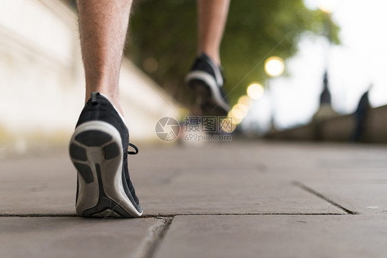 穿着运动鞋在人行道上跑步的年轻男性跑步者图片