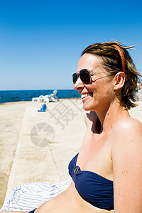 在海边晒日光浴的女人图片