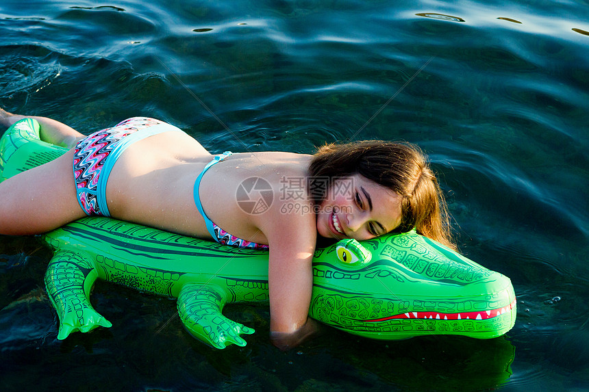 带着充气鳄鱼的海中女孩图片