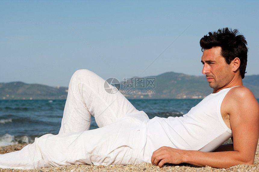 沙滩上享受阳光的男人图片