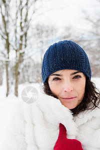 白雪皑皑的树林里的女人看着摄像机图片