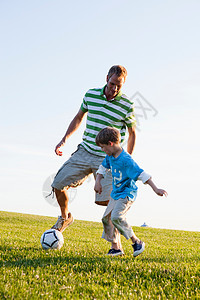 父子俩踢足球背景图片