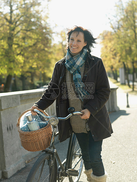 秋天在桥上骑自行车的女人图片