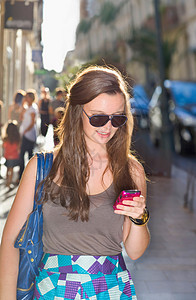 年轻女子在街上查手机图片