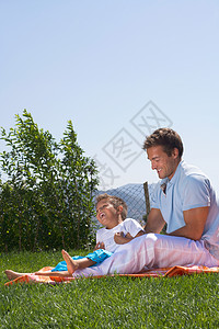 父子俩在野餐毯上玩耍图片