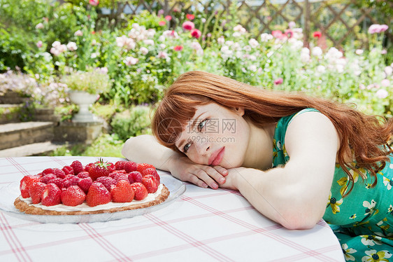 年轻女子看着草莓馅饼图片