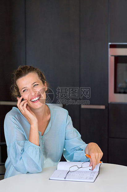 厨房里的女人在打电话图片