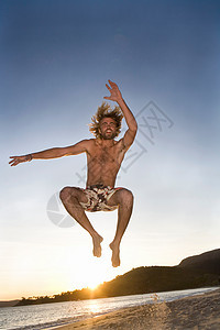 男人在海滩上跳跃图片