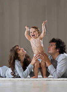 父母扶着婴儿站起来生活方式高清图片素材