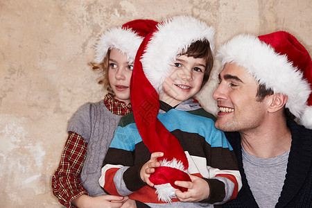 父亲和孩子们戴着圣诞帽图片