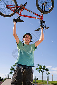 把自行车顶在头上的小男孩图片