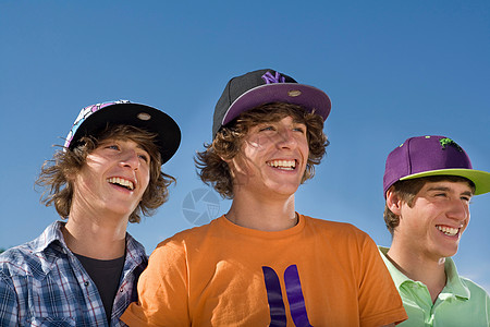 男孩们戴着棒球帽微笑着背景图片
