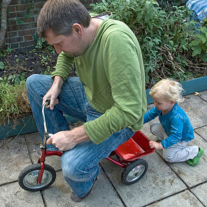 男孩推着父亲骑三轮车图片