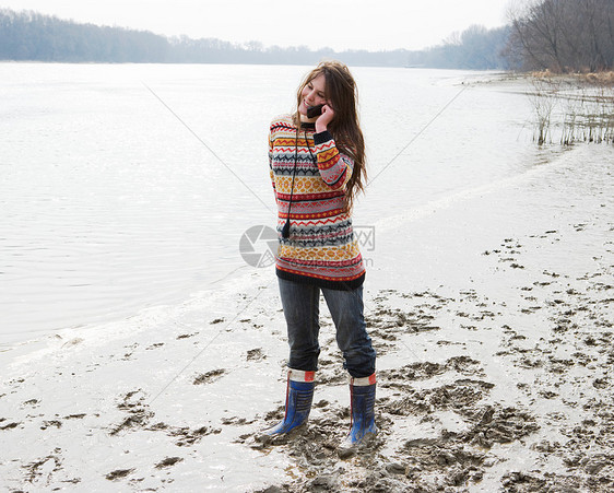 在河边打电话的年轻女子图片