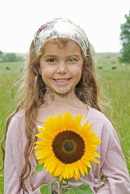 拿着向日葵在草地上的女孩图片