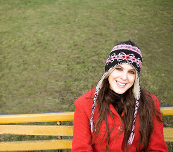 坐在长椅上戴帽子的年轻女子图片