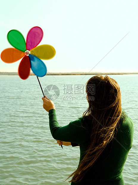 女孩举起玩具风车背影图图片