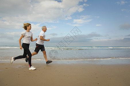 一对夫妇在海滩上奔跑图片素材