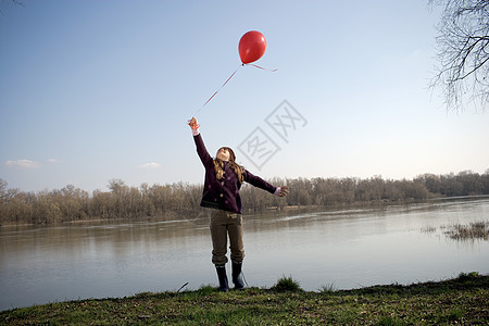 拿着红气球的河边女孩图片