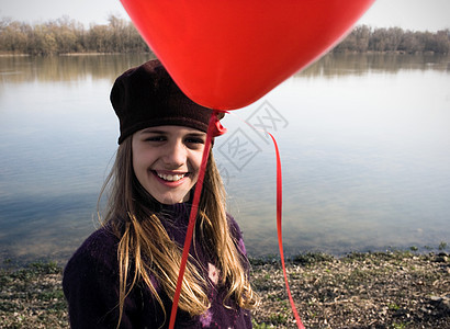 提着红气球的河边女孩图片