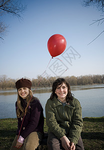 男孩和女孩在河边拿着气球图片