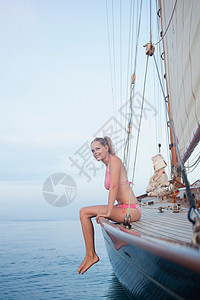 坐在帆船栏杆上的女人图片