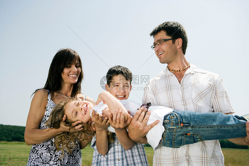 一家人抱着小女孩拍照图片