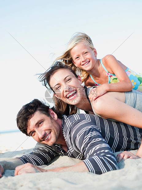 一家人趴在沙滩上微笑图片