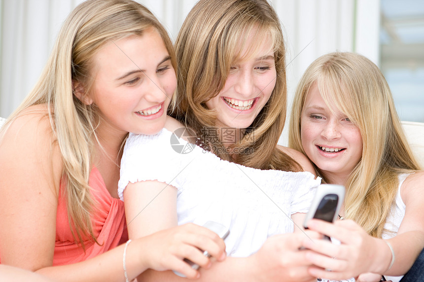 三个十几岁的女孩在看手机图片