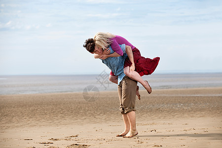 在海滩上玩得好开心的夫妇图片