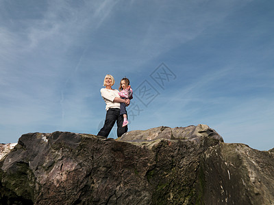 成熟的女人和孩子在岩石上图片