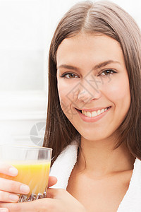 微笑的女人在喝橙汁图片