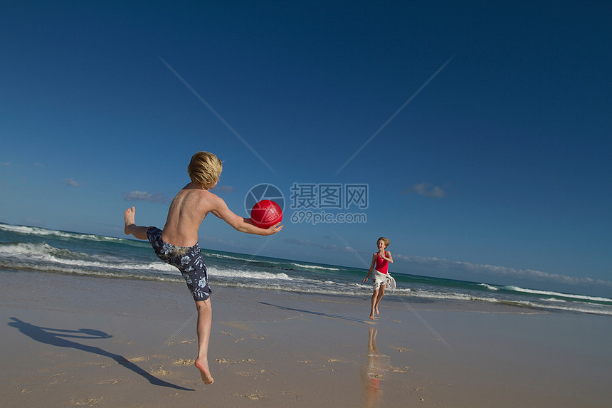 孩子们在沙滩上玩红球图片