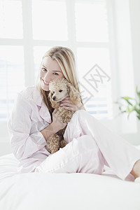 在床上抱着狗的女人图片