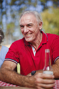 在野餐桌边喝酒的老人图片
