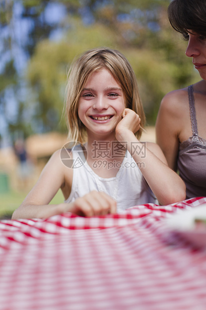 在野餐桌上微笑的女孩图片