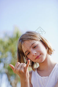 女孩用手指检查蜻蜓图片