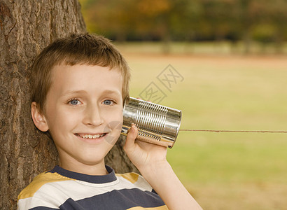 听锡罐电话的男孩图片
