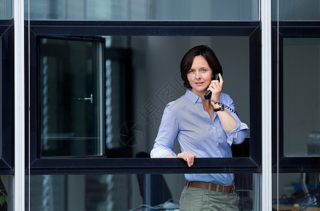 女商人望着办公室窗外图片